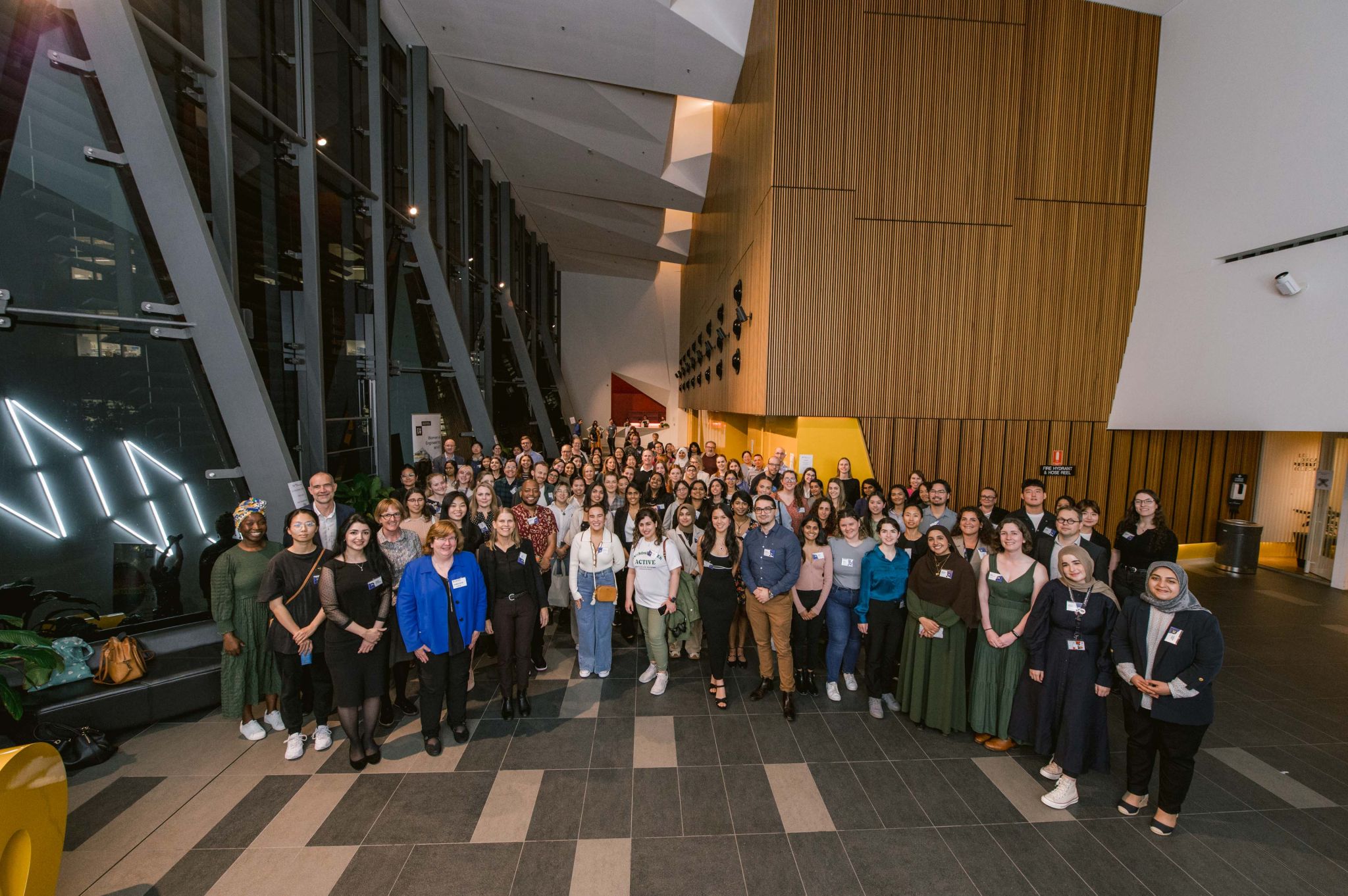 Large diverse group photo in a modern atrium after a women in tech or mentoring event.
